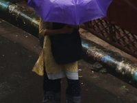 A woman walks on the street during rain due to Cyclone Dana in Kolkata, India, on October 25, 2024. The coastal districts of Odisha are batt...