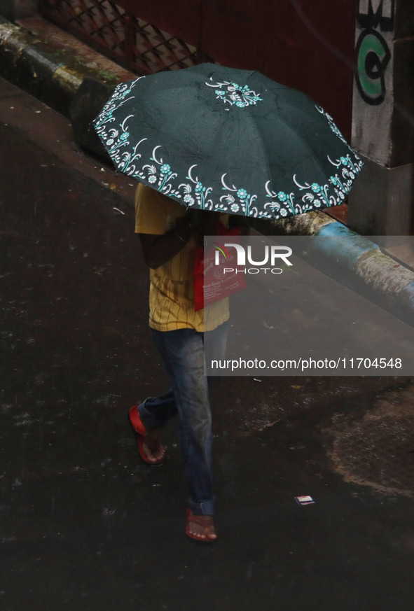 A man walks on the street during rain due to Cyclone Dana in Kolkata, India, on October 25, 2024. The coastal districts of Odisha are batter...