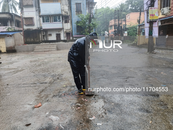 A Corporation worker works on the street during the heavy rain due to Cyclone Dana in Kolkata, India, on October 25, 2024. 