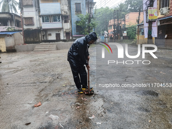 A Corporation worker works on the street during the heavy rain due to Cyclone Dana in Kolkata, India, on October 25, 2024. (