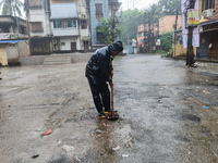 A Corporation worker works on the street during the heavy rain due to Cyclone Dana in Kolkata, India, on October 25, 2024. (