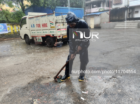 A Corporation worker works on the street during the heavy rain due to Cyclone Dana in Kolkata, India, on October 25, 2024. 