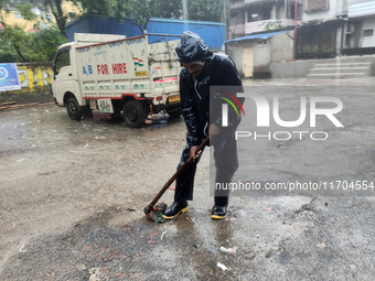 A Corporation worker works on the street during the heavy rain due to Cyclone Dana in Kolkata, India, on October 25, 2024. (