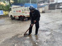 A Corporation worker works on the street during the heavy rain due to Cyclone Dana in Kolkata, India, on October 25, 2024. (