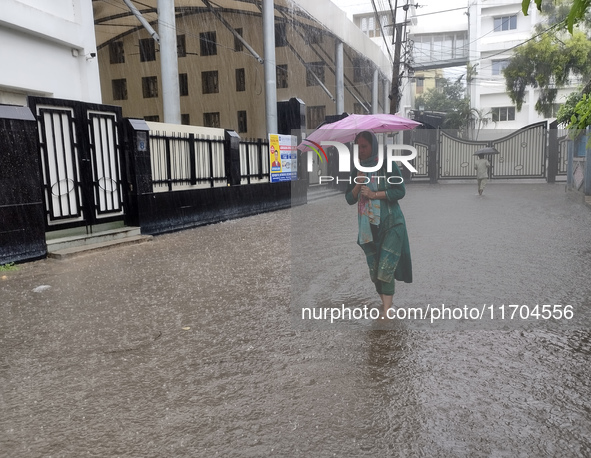 A woman walks on the waterlogged street during the heavy rain due to Cyclone Dana in Kolkata, India, on October 25, 2024. 