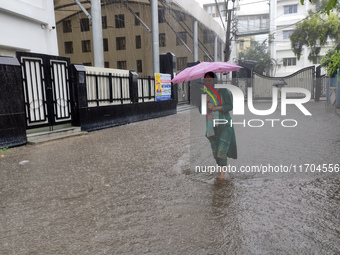 A woman walks on the waterlogged street during the heavy rain due to Cyclone Dana in Kolkata, India, on October 25, 2024. (