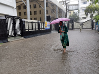 A woman walks on the waterlogged street during the heavy rain due to Cyclone Dana in Kolkata, India, on October 25, 2024. (