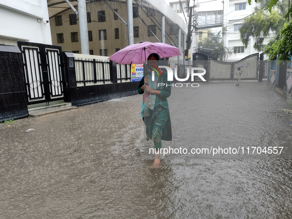 A woman walks on the waterlogged street during the heavy rain due to Cyclone Dana in Kolkata, India, on October 25, 2024. 