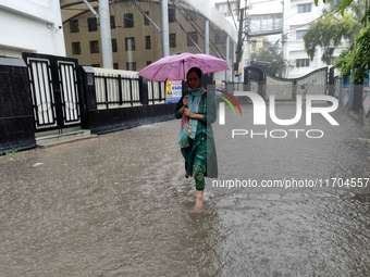 A woman walks on the waterlogged street during the heavy rain due to Cyclone Dana in Kolkata, India, on October 25, 2024. (