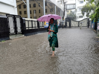 A woman walks on the waterlogged street during the heavy rain due to Cyclone Dana in Kolkata, India, on October 25, 2024. (