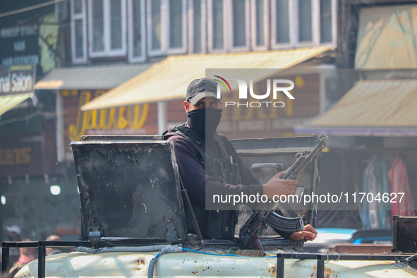 An Indian security personnel stands alert atop an armored vehicle along a road in Srinagar, Jammu and Kashmir, on October 25, 2024. Security...