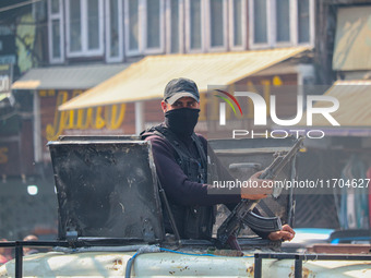 An Indian security personnel stands alert atop an armored vehicle along a road in Srinagar, Jammu and Kashmir, on October 25, 2024. Security...