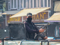 An Indian security personnel stands alert atop an armored vehicle along a road in Srinagar, Jammu and Kashmir, on October 25, 2024. Security...