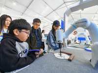 Citizens watch a performance of Chinese painting and calligraphy robot skills at the 7th World Sound Expo and IFLYtek Global 1024 Developer...