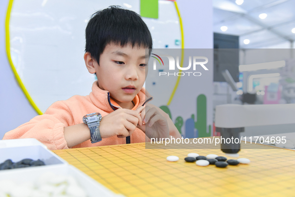 A child plays with a Go robot at the 7th World Sound Expo and the 2024 IFlyTEK Global 1024 Developer Festival in Hefei, China, on October 24...