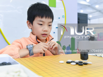 A child plays with a Go robot at the 7th World Sound Expo and the 2024 IFlyTEK Global 1024 Developer Festival in Hefei, China, on October 24...