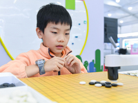 A child plays with a Go robot at the 7th World Sound Expo and the 2024 IFlyTEK Global 1024 Developer Festival in Hefei, China, on October 24...