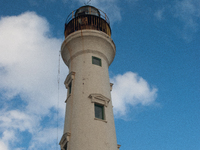 The California Lighthouse, known by locals as Faro, stands tall on a limestone plateau at Hudishibana, near Arashi Beach and Sasariwichi dun...