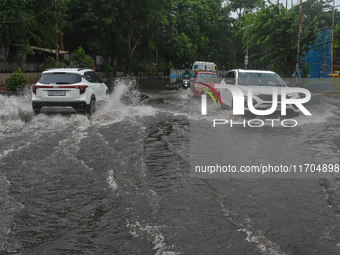 Motorists make their way through a flooded road after Cyclone Dana thrashes the city with heavy rain, as seen in Kolkata, India, on October...