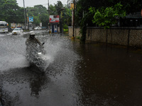 Motorists make their way through a flooded road after Cyclone Dana thrashes the city with heavy rain, as seen in Kolkata, India, on October...