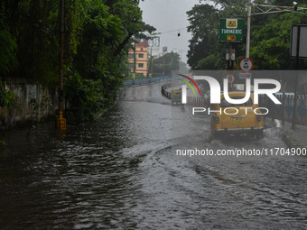 Motorists make their way through a flooded road after Cyclone Dana thrashes the city with heavy rain, as seen in Kolkata, India, on October...