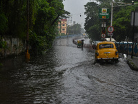 Motorists make their way through a flooded road after Cyclone Dana thrashes the city with heavy rain, as seen in Kolkata, India, on October...