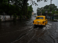 Motorists make their way through a flooded road after Cyclone Dana thrashes the city with heavy rain, as seen in Kolkata, India, on October...