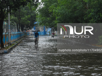 Motorists make their way through a flooded road after Cyclone Dana thrashes the city with heavy rain, as seen in Kolkata, India, on October...