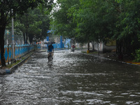 Motorists make their way through a flooded road after Cyclone Dana thrashes the city with heavy rain, as seen in Kolkata, India, on October...