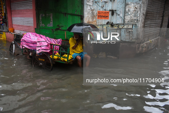 A man tries to escape water on a flooded road in Kolkata, India, on October 25, 2024, after heavy rain brought by the landfall of Cyclone Da...