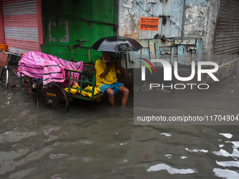 A man tries to escape water on a flooded road in Kolkata, India, on October 25, 2024, after heavy rain brought by the landfall of Cyclone Da...