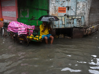 A man tries to escape water on a flooded road in Kolkata, India, on October 25, 2024, after heavy rain brought by the landfall of Cyclone Da...