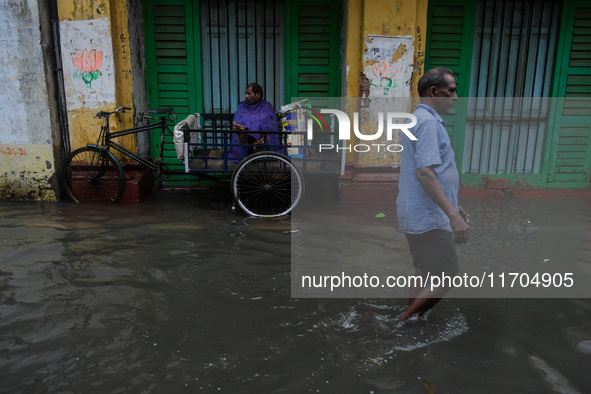 A man tries to escape water on a flooded road in Kolkata, India, on October 25, 2024, after heavy rain brought by the landfall of Cyclone Da...