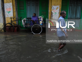 A man tries to escape water on a flooded road in Kolkata, India, on October 25, 2024, after heavy rain brought by the landfall of Cyclone Da...