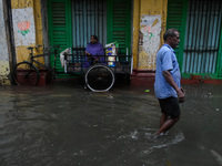 A man tries to escape water on a flooded road in Kolkata, India, on October 25, 2024, after heavy rain brought by the landfall of Cyclone Da...