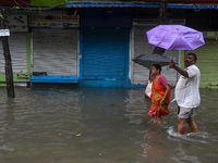 People are seen on a flooded road in Kolkata, India, on October 25, 2024, after heavy rain brought by the landfall of Cyclone Dana. Cyclone...