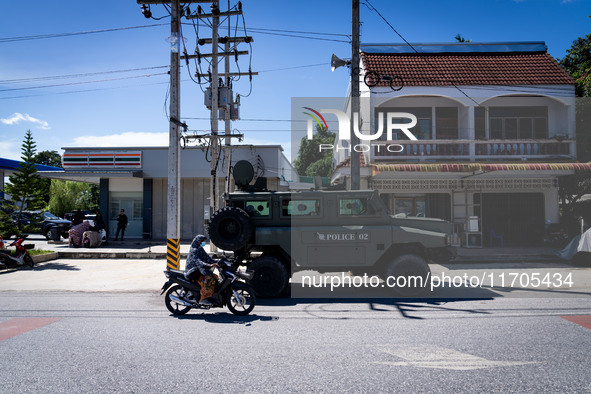 An army vehicle parks outside a 7-Eleven store where armed soldiers stand guard. Daily life in Tak Bai, Narathiwat, Thailand, on October 25,...