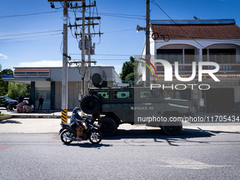 An army vehicle parks outside a 7-Eleven store where armed soldiers stand guard. Daily life in Tak Bai, Narathiwat, Thailand, on October 25,...