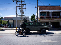 An army vehicle parks outside a 7-Eleven store where armed soldiers stand guard. Daily life in Tak Bai, Narathiwat, Thailand, on October 25,...