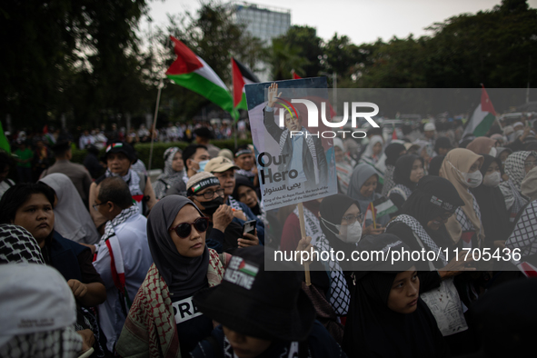 A protester holds a placard during a rally in solidarity with the Palestinian people outside the US embassy in Jakarta, Indonesia, on Octobe...