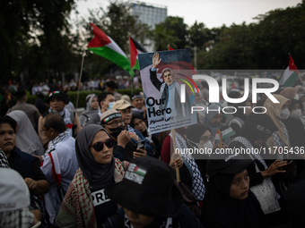 A protester holds a placard during a rally in solidarity with the Palestinian people outside the US embassy in Jakarta, Indonesia, on Octobe...