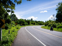 A motorcyclist rides on the rural highway between Pattani and Narathiwat. Daily life in Tak Bai, Narathiwat, Thailand, on October 25, 2024....