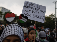 A protester holds a placard during a rally in solidarity with the Palestinian people outside the US embassy in Jakarta, Indonesia, on Octobe...