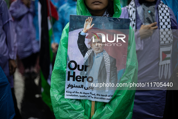 A protester holds a placard during a rally in solidarity with the Palestinian people outside the US embassy in Jakarta, Indonesia, on Octobe...