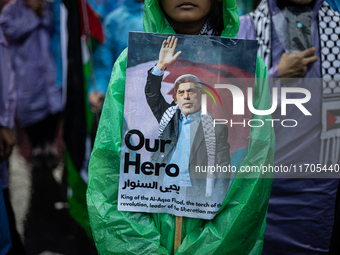 A protester holds a placard during a rally in solidarity with the Palestinian people outside the US embassy in Jakarta, Indonesia, on Octobe...