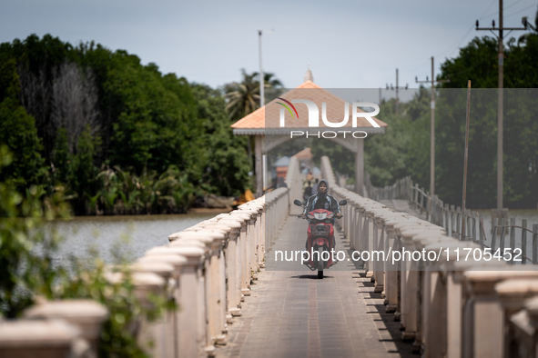 People ride motorcycles across a bridge in Tak Bai. Daily life in Tak Bai, Narathiwat, Thailand, on October 25, 2024. Tak Bai is the site of...