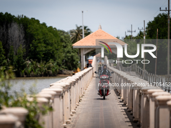 People ride motorcycles across a bridge in Tak Bai. Daily life in Tak Bai, Narathiwat, Thailand, on October 25, 2024. Tak Bai is the site of...