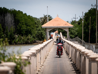 People ride motorcycles across a bridge in Tak Bai. Daily life in Tak Bai, Narathiwat, Thailand, on October 25, 2024. Tak Bai is the site of...