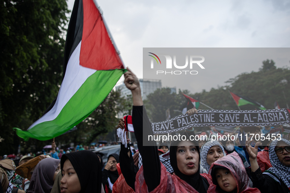 Protesters shout slogans during a rally in solidarity with the Palestinian people outside the US embassy in Jakarta, Indonesia, on October 2...