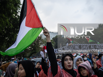 Protesters shout slogans during a rally in solidarity with the Palestinian people outside the US embassy in Jakarta, Indonesia, on October 2...